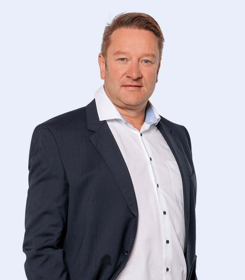 Mann im Anzug vor blauem Hintergrund.