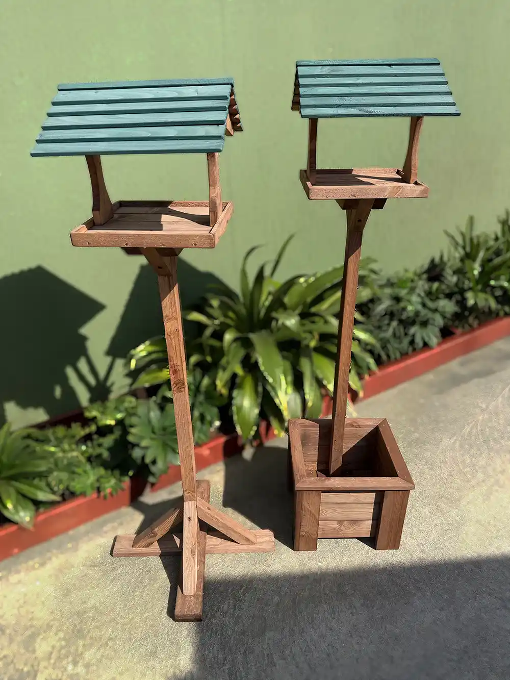 Two types of handmade wooden bird tables made from recycled wood, stained and painted.