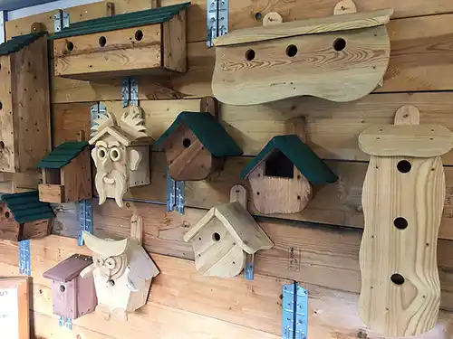 Various recycled wooden Bird Boxes mounted on the wall at the Turning Corners factory shop