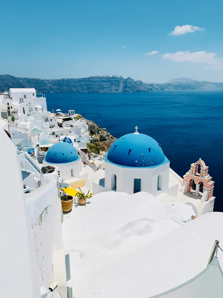 Vation in Santorini with whitewashed wall and views of the crystal blue sea