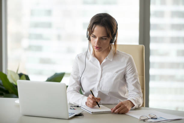 Image of a translator working wth a headset and a laptop