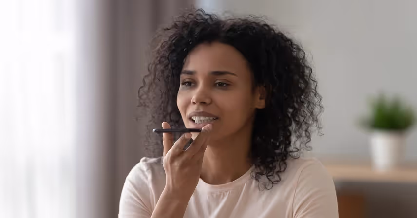 a person with curly hair talking into a cell phone