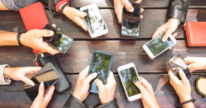 a group of hands holding cell phones
