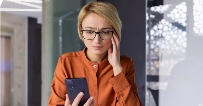 a woman holding and looking at a mobile phone