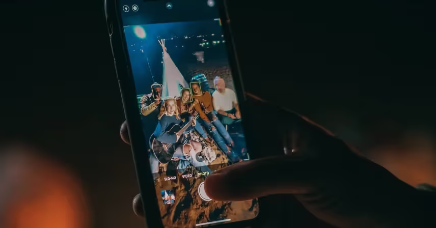 a hand holding a cell phone with a group of people on it