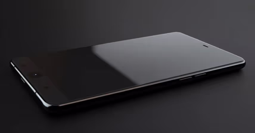 a black cell phone laying flat 