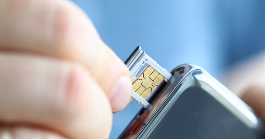 male hands getting sim card slot of his smartphone out