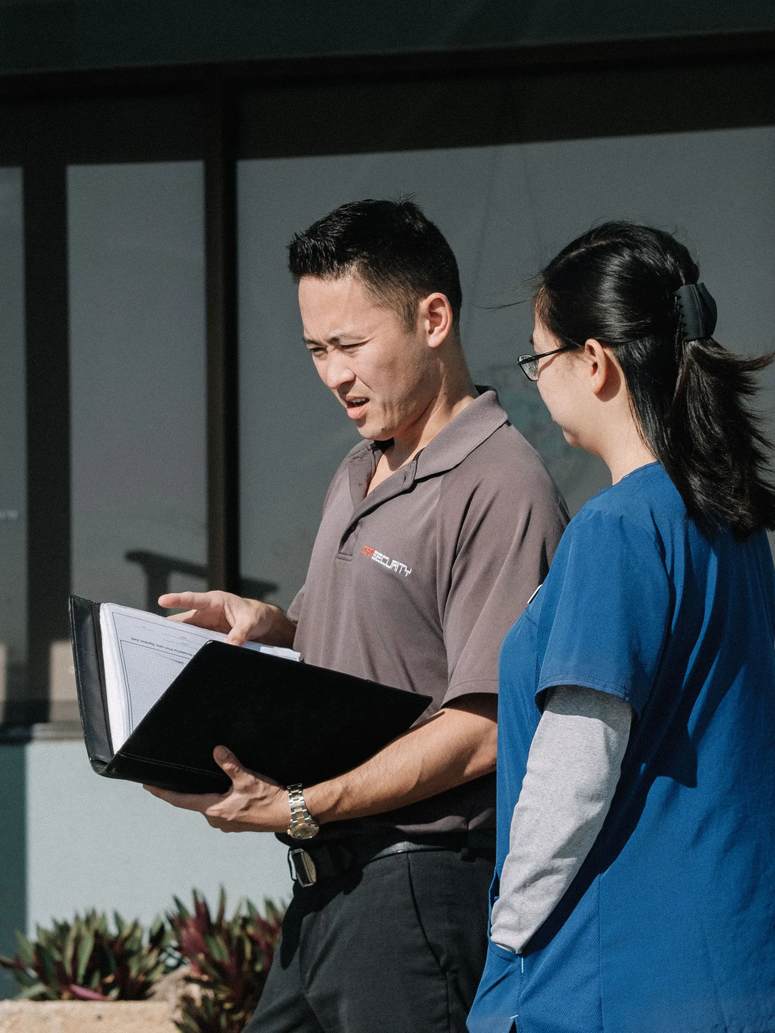 Cam Security owner standing next to client with a binder discussing security options