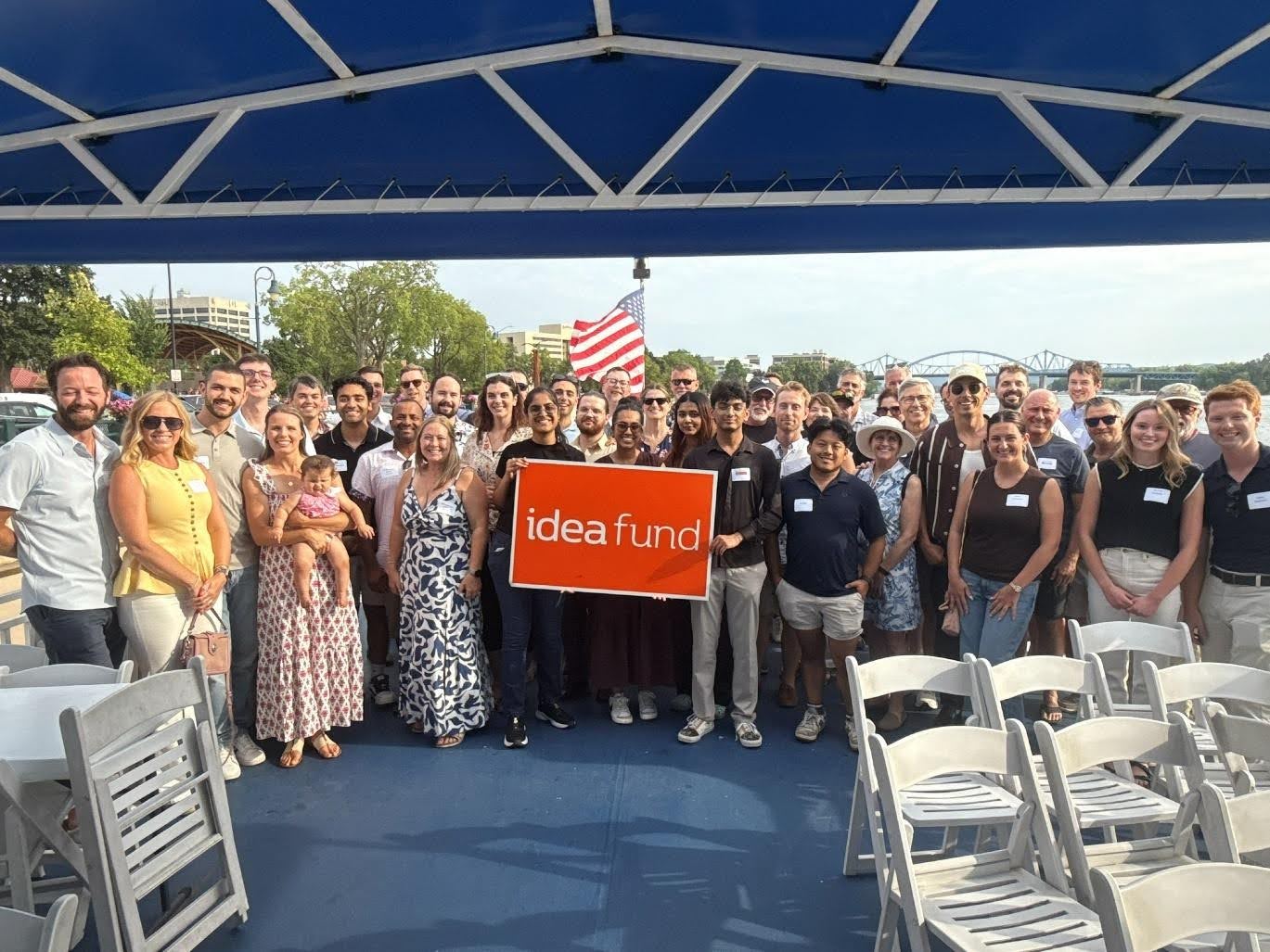 Idea Fund team members and portfolio company founders gathered on the deck of a riverboat cruise, holding an Idea Fund sign