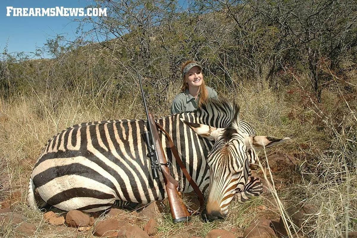 Brittany Boddington with her pet Kimber 7mm-08 and a mountain zebra in Namibia.