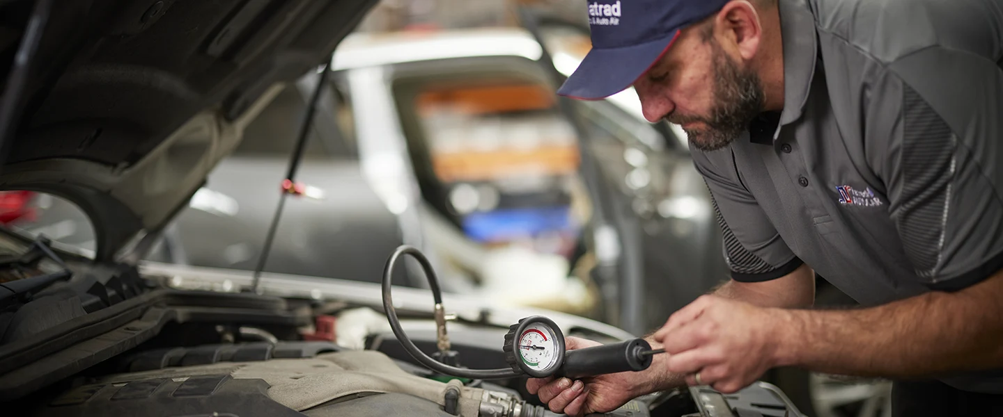 Mechanic checking car engine pressure with diagnostic tool