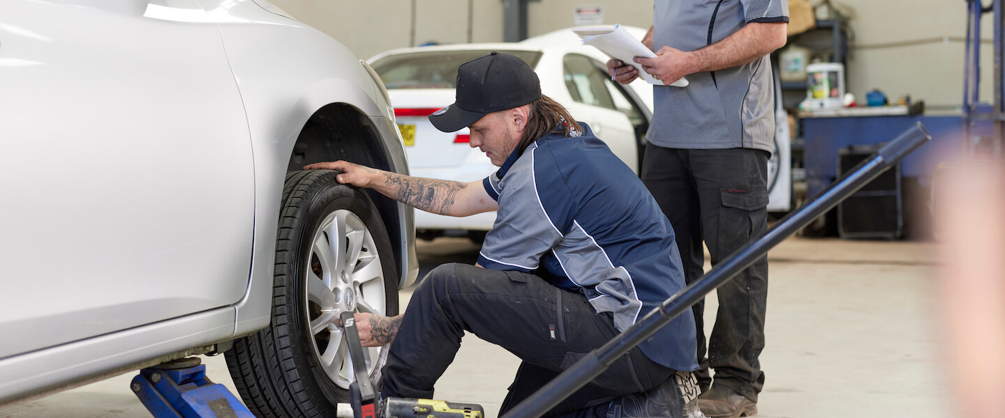 Mechanic checking tire pressure in auto repair shop