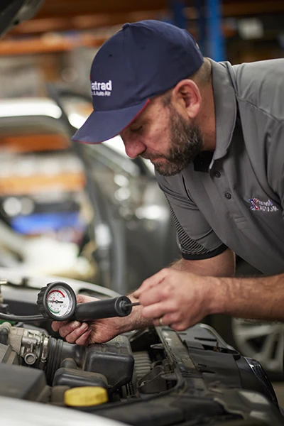 Mechanic checking engine pressure with diagnostic tool in workshop