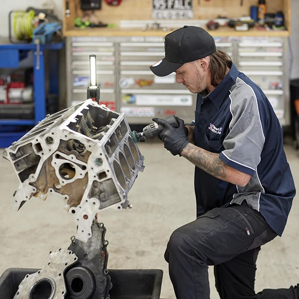 Mechanic inspecting a large engine block in a workshop
