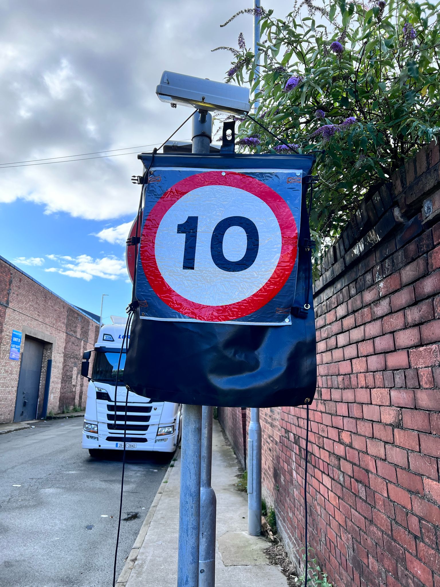 Signal head and road sign covered with CoverMe covers at a roadworks site