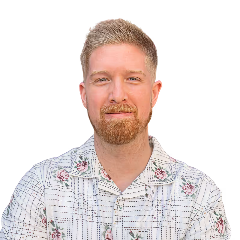 Smiling Chandler Dutton with light hair and beard wearing a white shirt with floral and grid patterns.