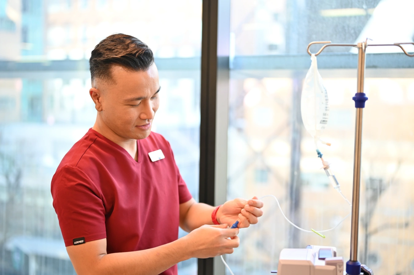 Healthcare Worker adjusting IV (intravenous) drip set up
