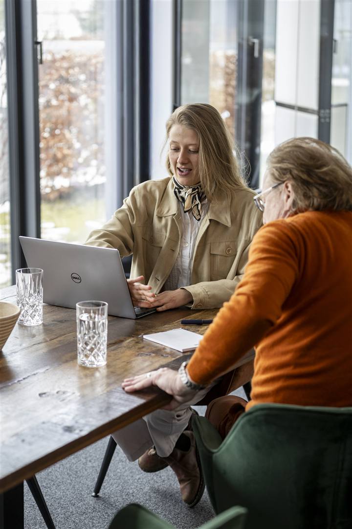 Theresa Rahm zeigt einem Geschäftsführer die Ergebnisse am Laptop