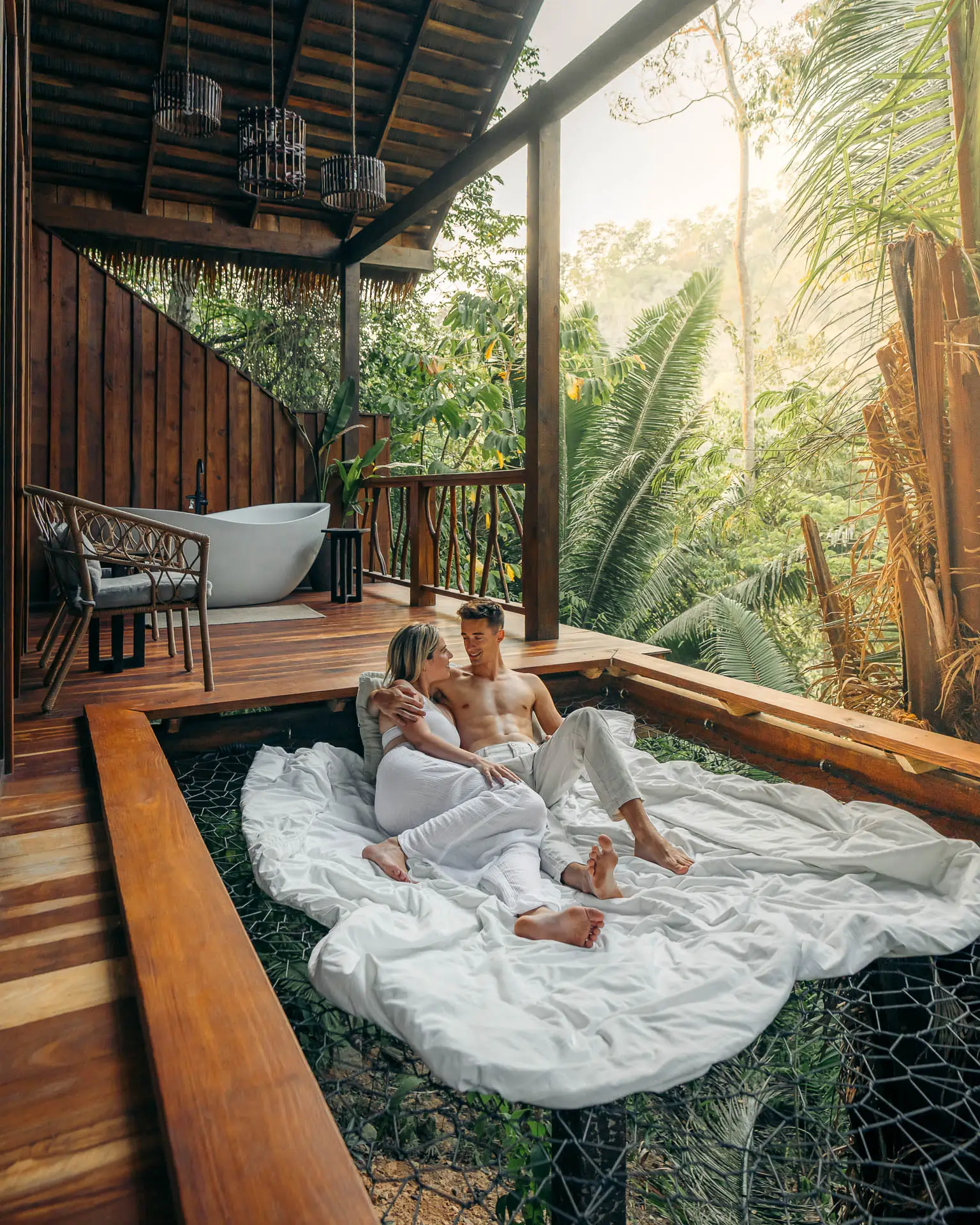 Couple relaxing on a jungle net balcony at Sweet Songs Jungle Lodge in Belize.