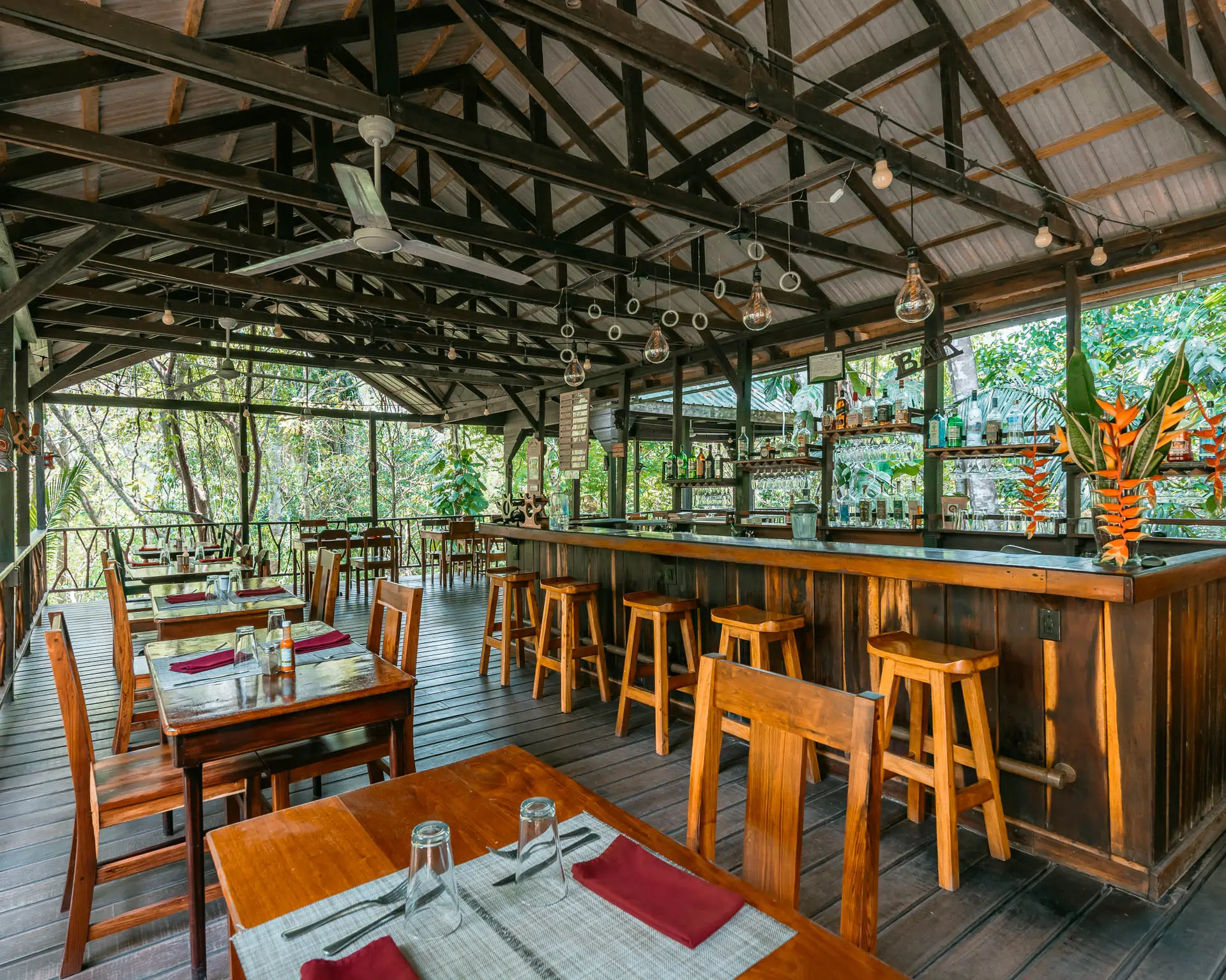 Wooden open-air restaurant and treehouse bar in the rainforest at Sweet Songs Jungle Lodge Belize