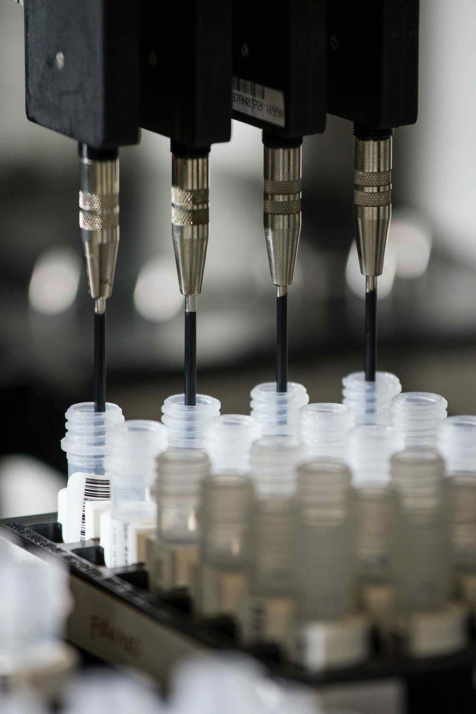 Automated pipetting heads adding reagent into rows of clear microcentrifuge tubes held in a black rack
