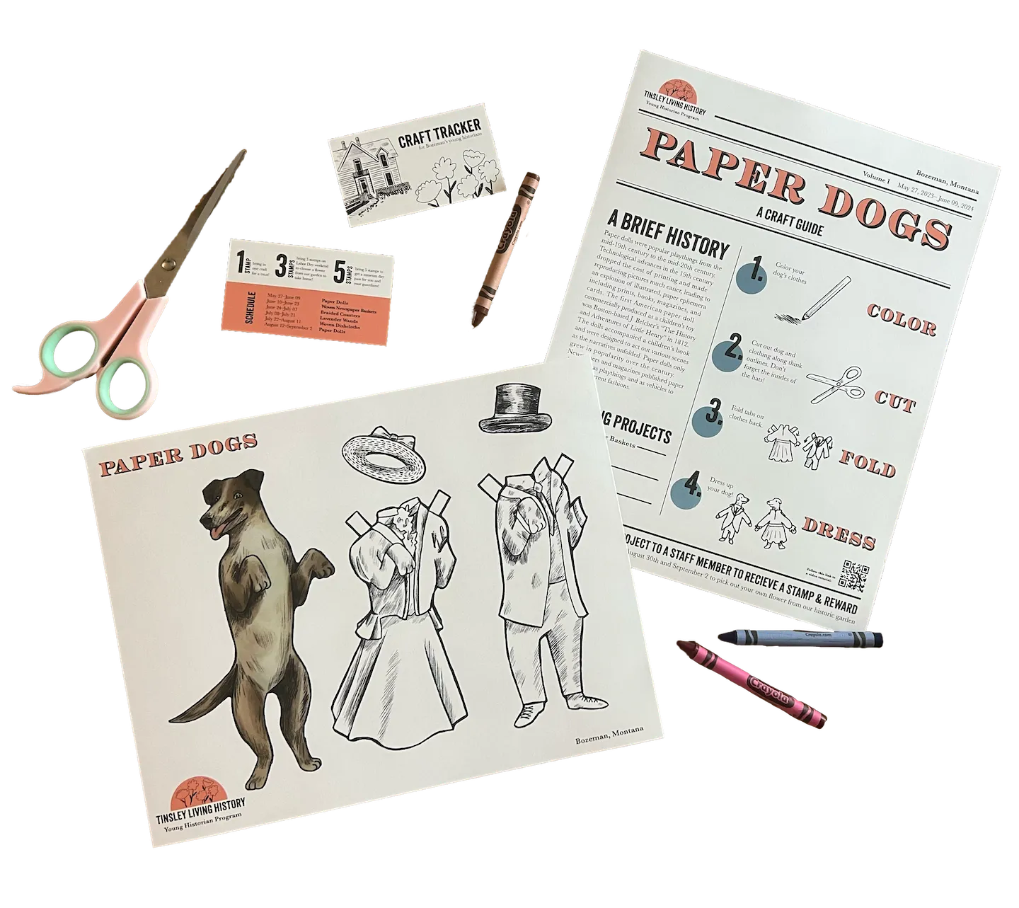 Scissors, crayons, and paper craft sheets for making paper dogs with outfits, including instructions and a craft tracker card.