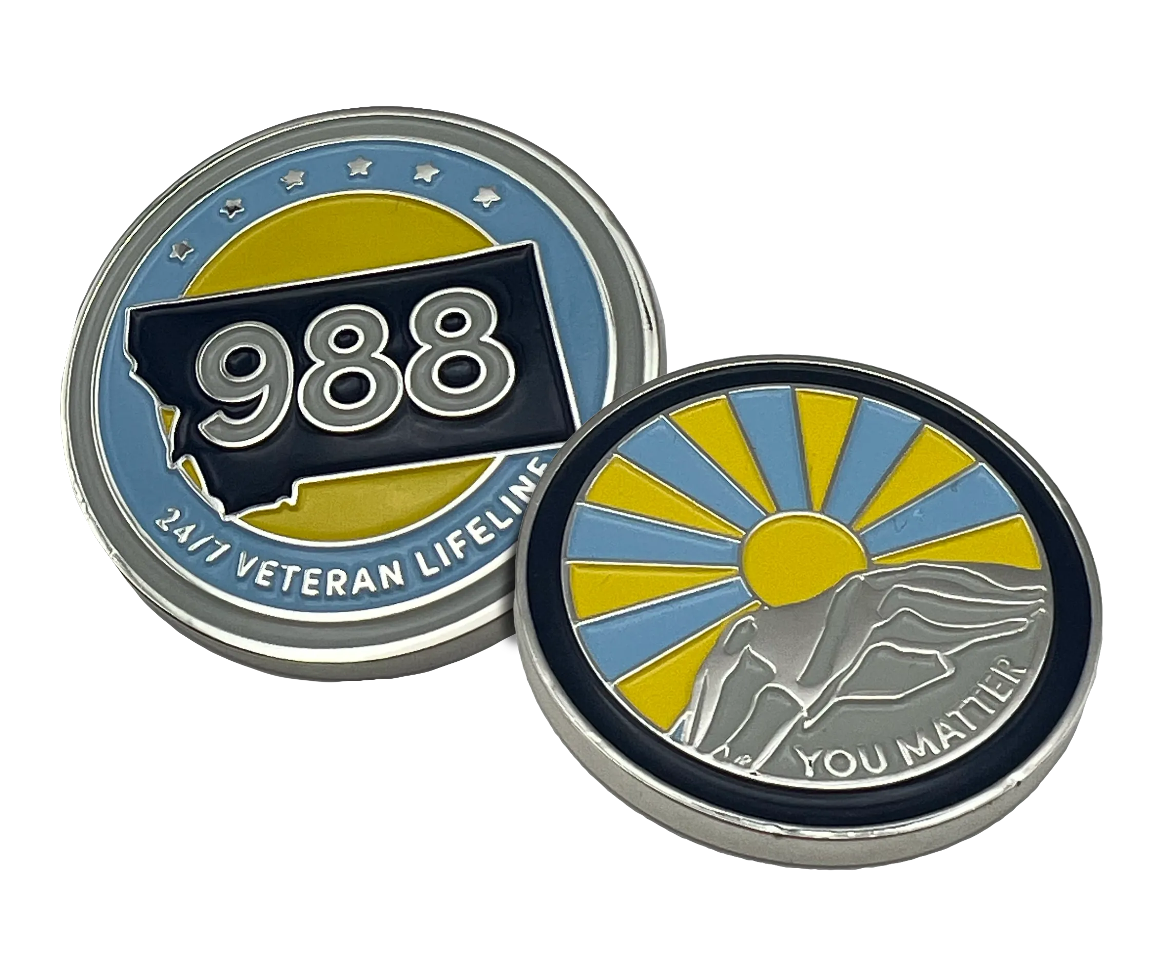 Two commemorative coins, one showing Montana state with number 988 and text '24/7 Veteran Lifeline', the other showing a sunrise behind resting hands and text 'You Matter'.