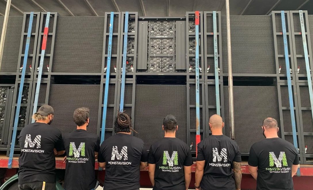 New Zealand crew in front of LED screen panels loaded on a truck