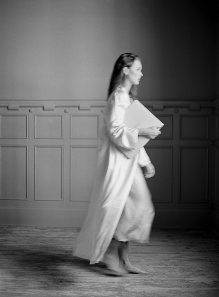 woman walking with wedding photo book under arm