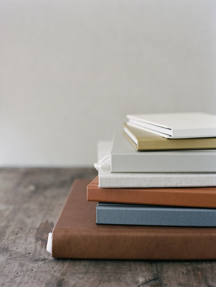 a stack of different sized handmade wedding albums