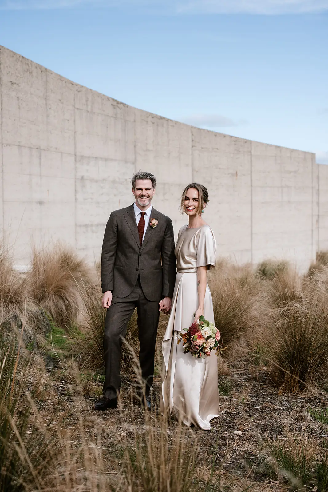 The front cover of The Mornington Peninsula Wedding Guide, featuring a newly wed couple sharing an intimate embrace whilst holding champagne.