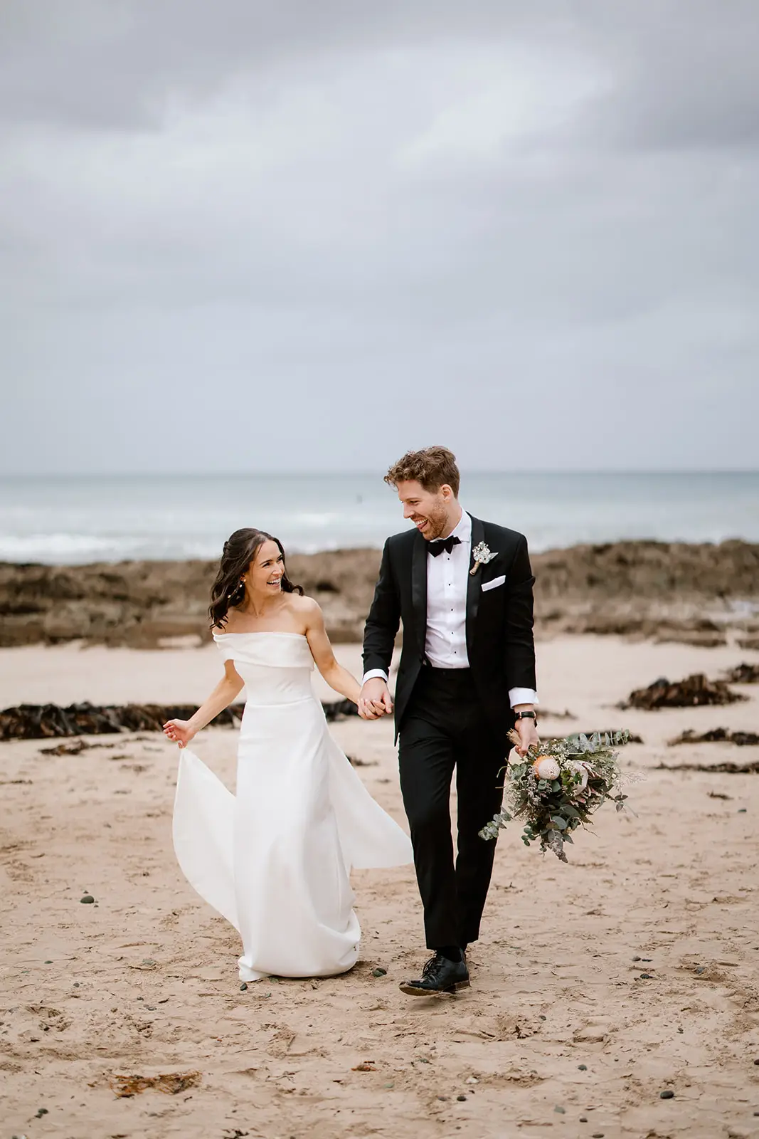 The front cover of The Mornington Peninsula Wedding Guide, featuring a newly wed couple sharing an intimate embrace whilst holding champagne.