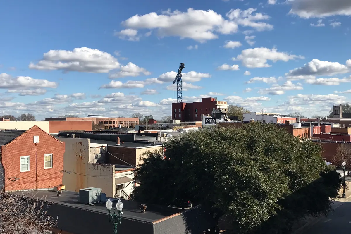 Rooftops and brick buildings of downtown Concord, North Carolina, under a blue sky