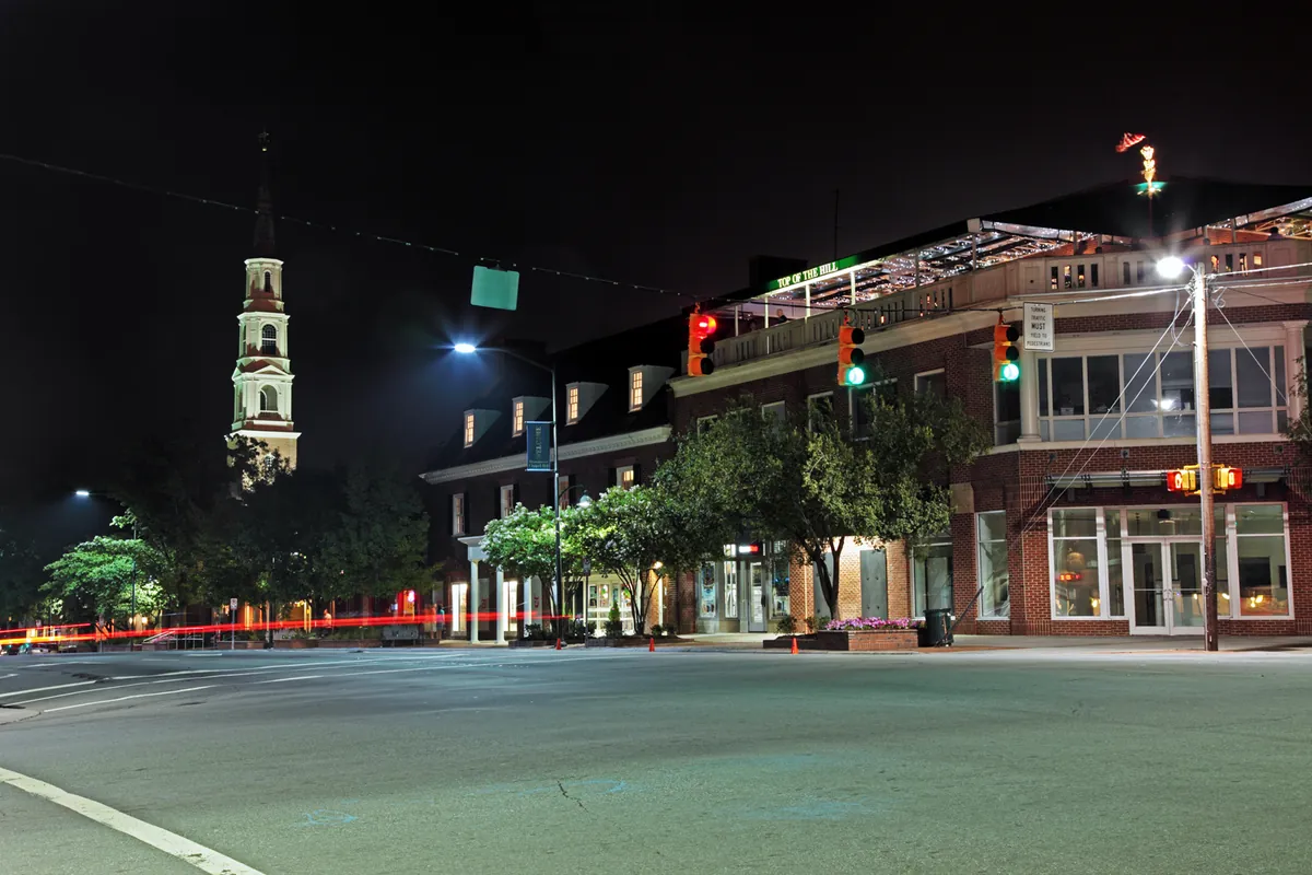Franklin Street and Columbia Street in downtown Chapel Hill, North Carolina, at night, with a church steeple lit up