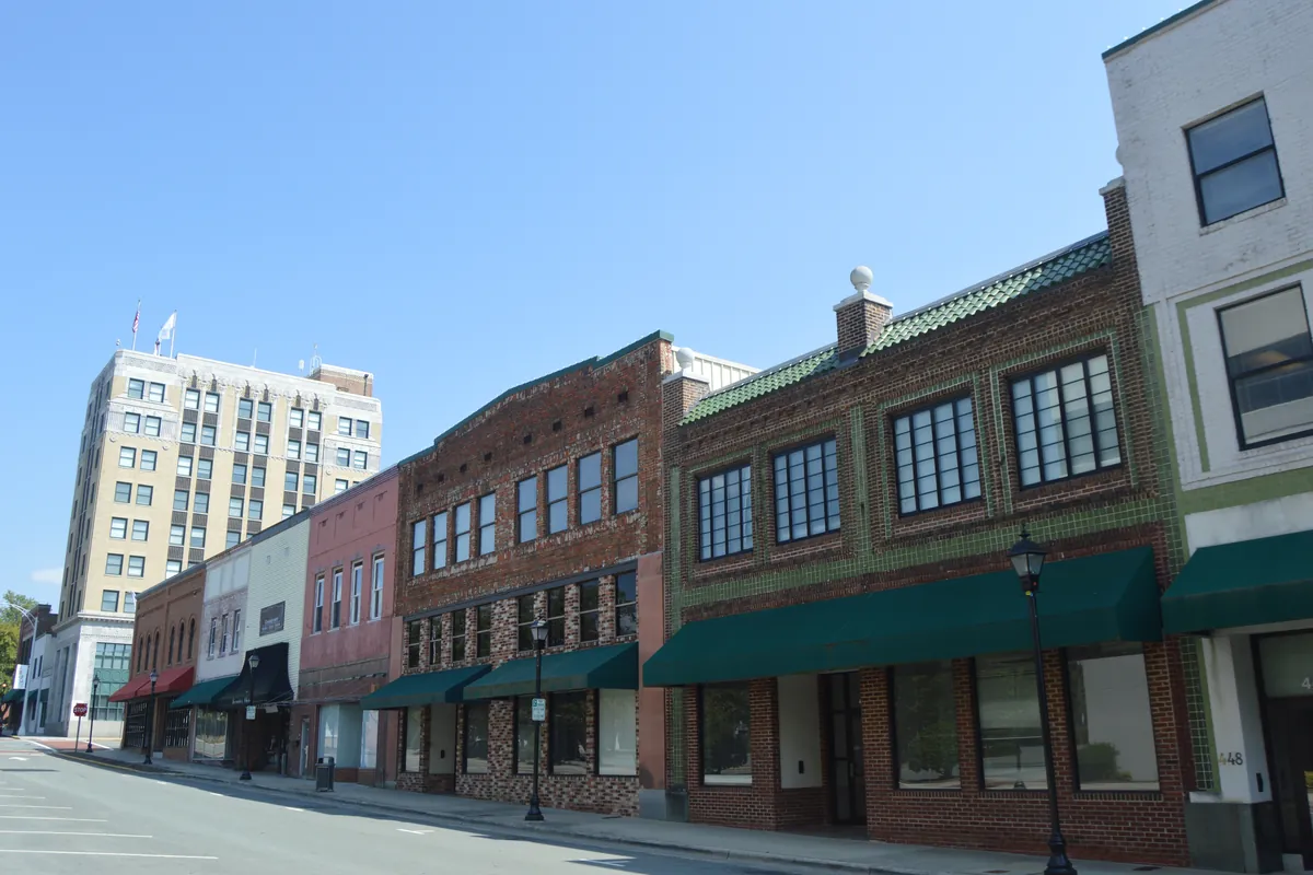Brick storefronts with green awnings along Main Street in downtown Burlington, North Carolina