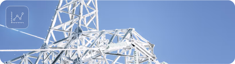Frost-covered transmission tower under clear blue sky representing energy infrastructure resilience