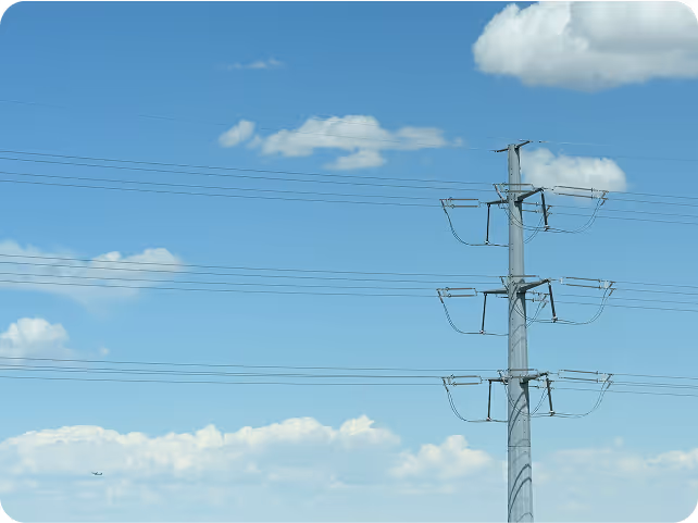 Power transmission line tower against a blue sky symbolizing electricity distribution and grid infrastructure