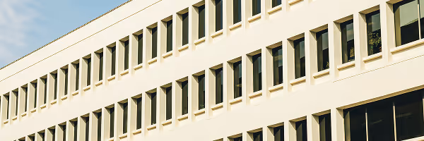 Modern white office building exterior with rows of vertical windows