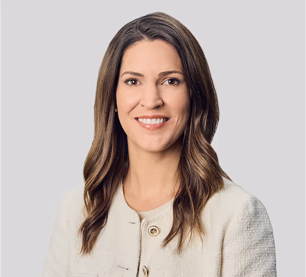 Professional headshot of woman with long highlighted brown hair wearing cream colored blazer