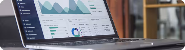 Laptop displaying Amperon analytics dashboard with graphs and pie charts showing energy data and forecasts