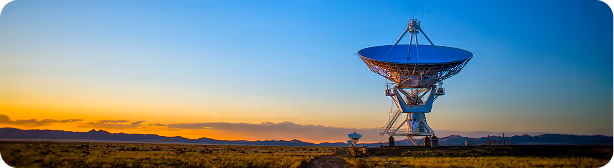 Large radio telescope dish at sunset in desert landscape