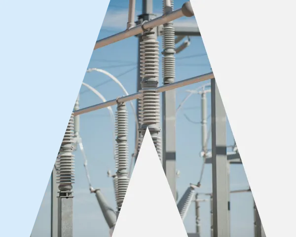 Electrical insulators and metal structures at a power substation against a blue sky.