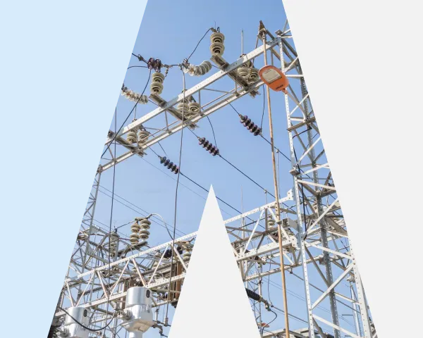 Electric power lines and insulators on a metal utility tower against a clear blue sky.