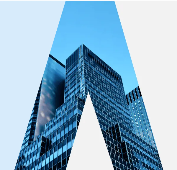 View of a modern glass skyscraper against a clear blue sky with reflections on its windows.