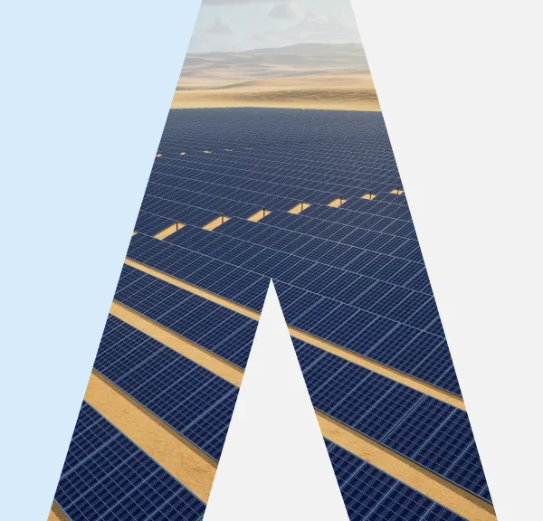 Large solar panel farm in a desert landscape under a partly cloudy sky.