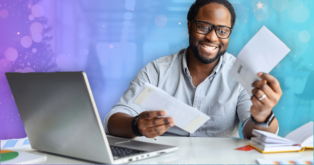 A man opens his direct mail at his desk during the holidays.
