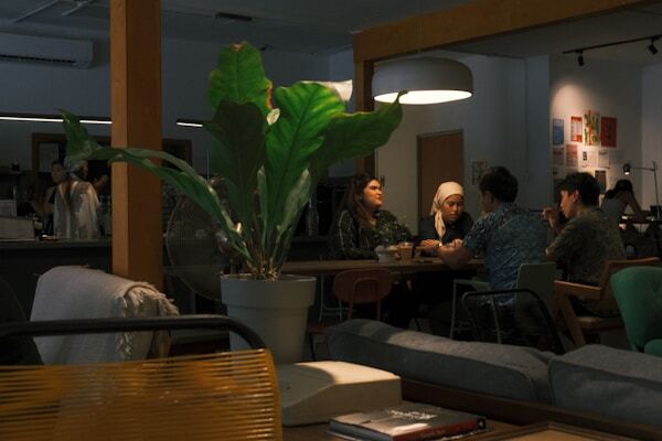 A group of people in conversation around a table in a cafe