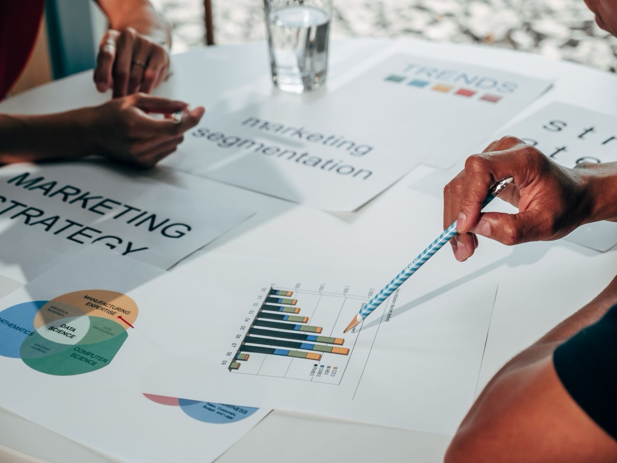 Team reviewing marketing strategy documents and charts around a table