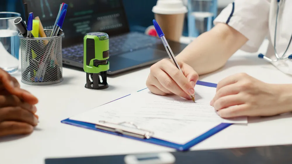 person filling up a form on a desk