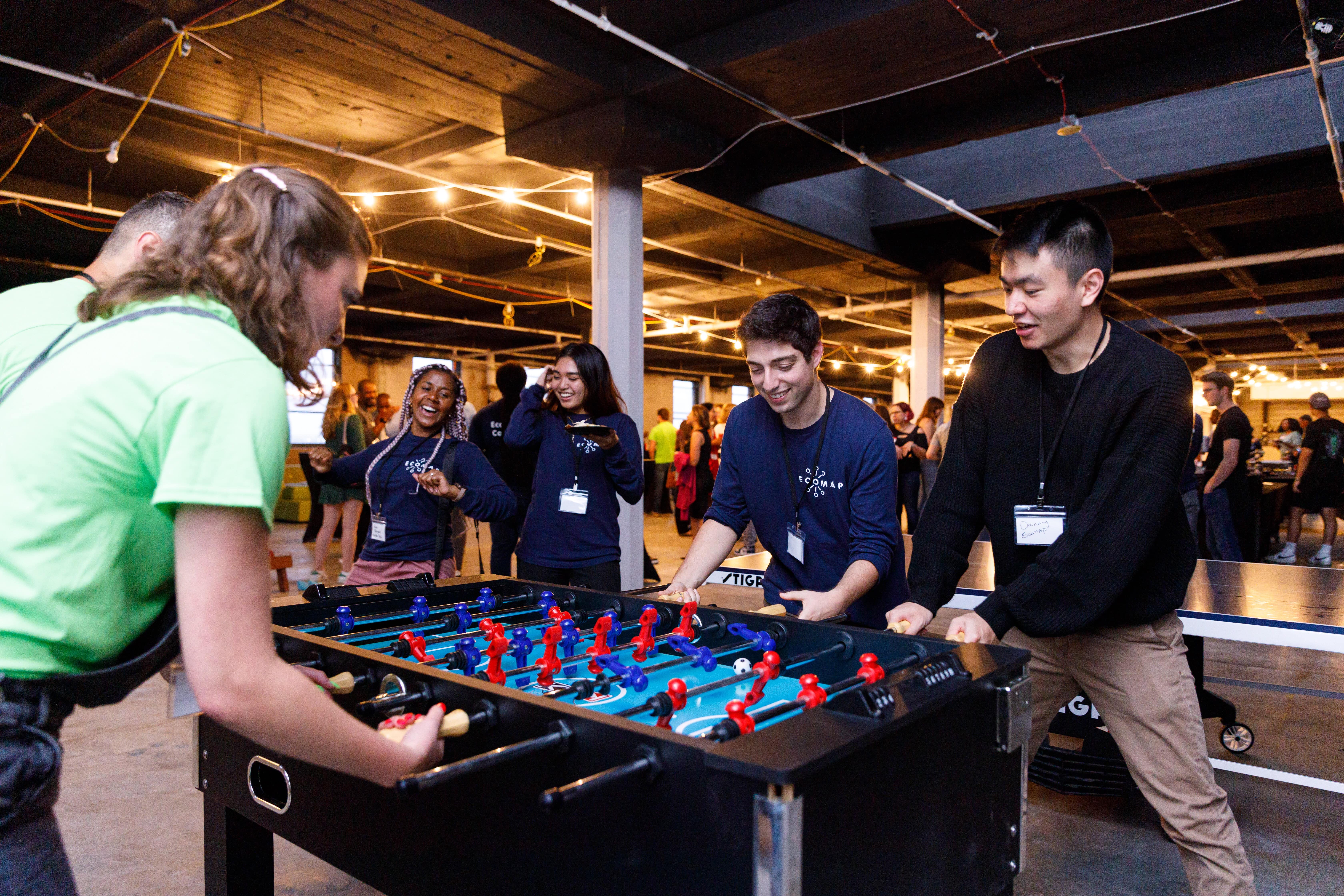 a photo of team members playing foosball